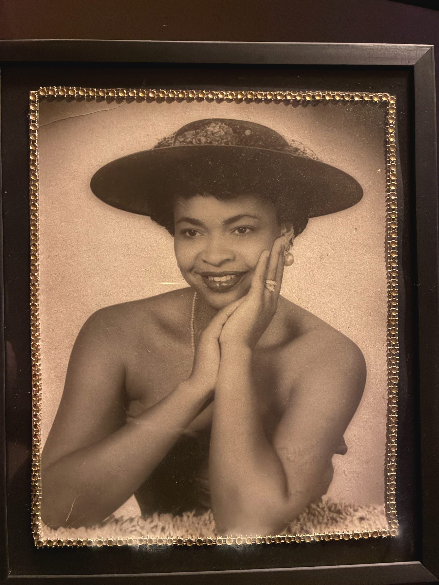 A vintage portrait of a young Barbra Hazely wearing a wide-brimmed hat